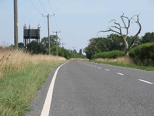 [PHOTO: straight open road with tree and water-tower: 108kB]
