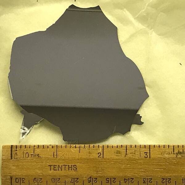 [PHOTO: Sliver of primary mirror on napkin, with ruler for scale: 32kB]